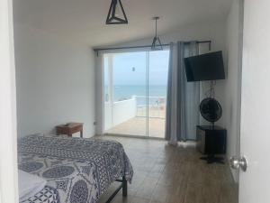 a bedroom with a bed and a large window with a view at Sunset Bay Colan in Colán