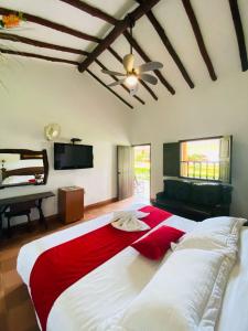ein Schlafzimmer mit einem großen Bett mit einer roten Decke in der Unterkunft Hotel Hacienda Santa Barbara in San Gil