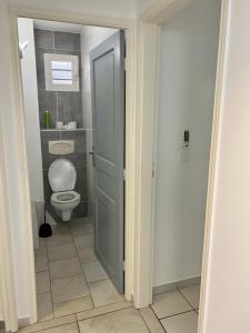 a bathroom with a toilet and a door open at Marina Hill Appartement vue mer in Le Gosier