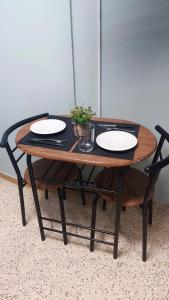 a wooden table with two plates on top of it at Praxitelous CityCenter Modern Apartments by Aesthetic Living in Athens