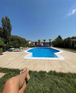 a woman laying on the grass next to a swimming pool at Residence Provence New in Vrdnik