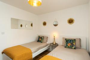 two beds in a room with white walls at Wyllie Mews in Burton upon Trent