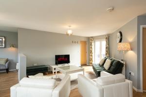 a living room with white furniture and a fireplace at Wyllie Mews in Burton upon Trent