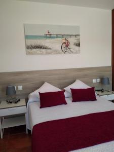 una camera da letto con un letto con cuscini rossi e una bicicletta sul muro di TROPICAL PARADISE a Tarajalejo