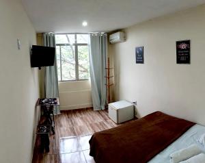 um quarto com uma cama e uma janela em Pousada Cantinho do Joá no Rio de Janeiro