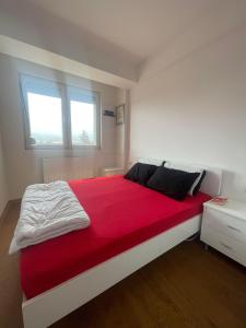 1 dormitorio con 1 cama grande con manta roja en Apartment Lazar en Skopje