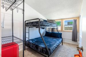 Wills PointにあるOld Texas Bunkhouseのベッドルーム1室(二段ベッド2台、赤いスーツケース付)