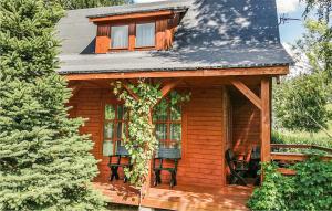 a log cabin with two chairs and a window at Beautiful Home In Kartuzy With Kitchen in Kartuzy