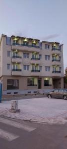 a large building with a car parked in front of it at Apartment Lazar in Skopje