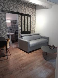 un salon avec un canapé et une table dans l'établissement Petit cocon en plein centre historique d'Uzès - Place aux herbes en zone piétonnière, à Uzès