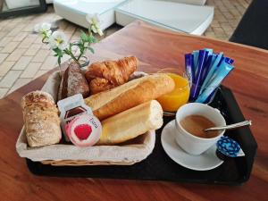 a tray of bread and croissants and coffee on a table at La Factory in Porrentruy