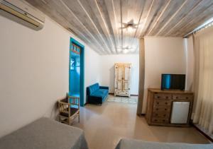 a living room with a blue couch and a television at Ville Real Hotel in Santo Antônio do Leite