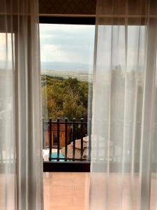 a view of a balcony from a window with curtains at Cardinale Resort in Iaşi