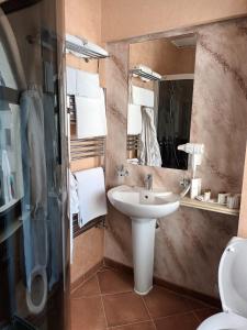 y baño con lavabo, espejo y aseo. en Cardinale Resort en Iaşi