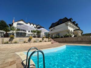 a house with a swimming pool in front of a house at Cardinale Resort in Iaşi