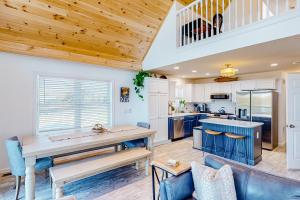 a kitchen and living room with a wooden ceiling at Bridgeview Retreat in North Hero