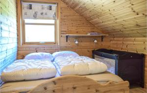 een slaapkamer met 2 bedden in een houten hut bij Beautiful Home In Os With Kitchen 