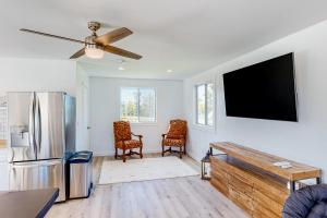 ein Wohnzimmer mit einem Kühlschrank und einem Flachbild-TV in der Unterkunft Bridgeview Retreat in North Hero
