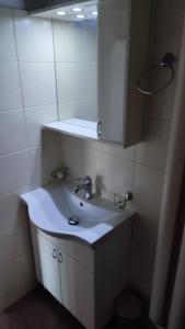 y baño con lavabo blanco y espejo. en Nice apartment in New Belgrade with free parking, en Belgrado