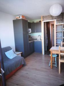 a room with a bed and a table and a kitchen at Appartement Le Corbier La Voie Lactée in Villarembert