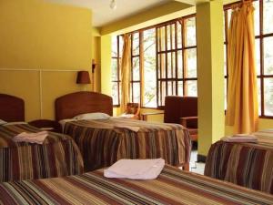 Cette chambre d'hôtel dispose de 2 lits et de fenêtres. dans l'établissement Hostal La Payacha, à Machu Picchu