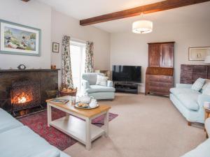 a living room with a couch and a fireplace at Nant Y Wyddan in Criccieth