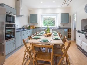 a kitchen with a wooden table and chairs in a kitchen at Nant Y Wyddan in Criccieth