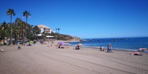 een groep mensen op een strand met de oceaan bij Serenity sea view in Estepona