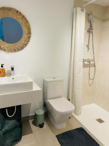 een badkamer met een wastafel, een toilet en een spiegel bij Serenity sea view in Estepona