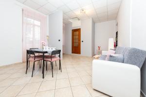 uma sala de jantar com uma mesa e cadeiras e um sofá em La Gioiosa - Top Location - Modern Apartment Near Metro Bengasi em Turim