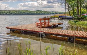 a wooden dock on a lake with a boat at Gorgeous Home In Gietrzwald With Kitchen in Kręsk