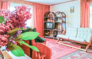 a living room with a couch and a table with flowers at Gorgeous Home In Gietrzwald With Kitchen in Kręsk