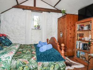 Un dormitorio con una cama con un osito de peluche azul. en Carminow Barn en Bodmin