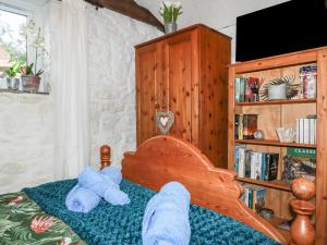 dos ositos de peluche sentados en una cama en Carminow Barn en Bodmin