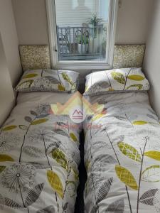 2 nebeneinander sitzende Betten in einem Schlafzimmer in der Unterkunft Trekker's Rest, Brigham, Cockermouth, Cumbria in Cockermouth