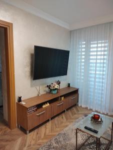 uma sala de estar com uma televisão de ecrã plano na parede em Decebal Premium Confort em Craiova