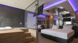 a bedroom with a bed and a bathroom with a sink at Bangalô Motel e Hotel by Drops in Santa Maria +35 photos