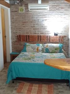 Bett in einem Zimmer mit Ziegelwand in der Unterkunft TENDERETE in Villa General Belgrano