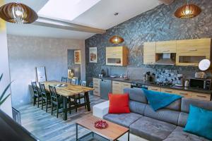 a living room and kitchen with a couch and a table at Gîte chez Thomas et John in Verdun-sur-Meuse
