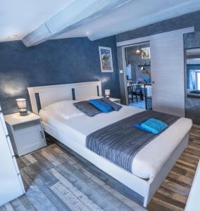sypialnia z dużym białym łóżkiem z niebieskimi poduszkami w obiekcie Chambre d'hôte et gîte chez Thomas et John w mieście Verdun