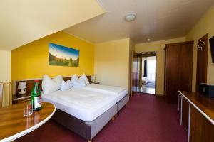 ein Hotelzimmer mit einem großen Bett und einem Schreibtisch in der Unterkunft Hotel Altneudörflerhof in Bad Radkersburg