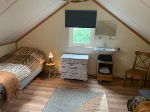 una camera da letto con un letto e un lavandino in mansarda di Het Slakkenhuisje a Maarn