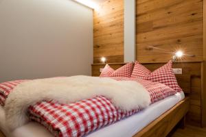 1 dormitorio con 1 cama con almohadas rojas y blancas en Berghotel Chäserstatt, en Ernen