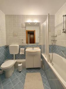 a bathroom with a toilet and a sink and a tub at Lovely & quiet 1-bedroom condo with free parking in Bucharest