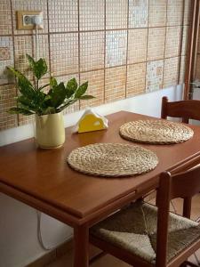 una mesa de madera con dos platos y una planta en ella en Lovely & quiet 1-bedroom condo with free parking, en Bucarest