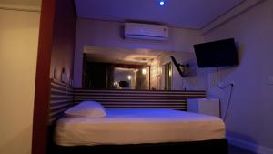 a bedroom with a bed with a purple ceiling at Bangalô Motel e Hotel by Drops in Santa Maria