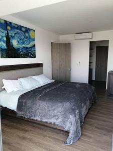 a bedroom with a large bed with a painting on the wall at Queretaro Dep de lujo, para 5 o 6 huéspedes, alberca in Querétaro +50 photos