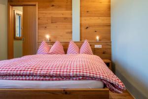 1 dormitorio con 1 cama con almohadas rojas y blancas en Berghotel Chäserstatt, en Ernen