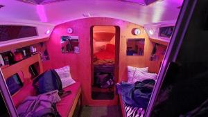Habitación rosa con camas y espejo. en VOILIER AU SOLEIL LEVANT, en Le Havre