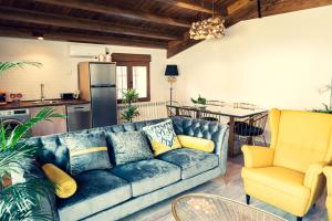 a living room with a blue couch and a kitchen at Apartamentos en el Valle del Jerte Flores para Angela in Cabezuela del Valle